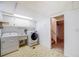 Well-equipped laundry room with washer, dryer, sink, and ample cabinet space for easy organization at 12218 Monroe Dr, Thornton, CO 80241