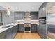 Modern kitchen with stainless steel appliances, gray cabinetry, a tile backsplash, and hardwood floors at 1590 Little Raven St # 408, Denver, CO 80202