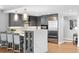 Kitchen includes an island with seating, stainless steel appliances, gray cabinets, and hardwood floors at 1590 Little Raven St # 408, Denver, CO 80202