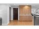 Kitchen featuring natural wood cabinets, stainless steel appliances, and hardwood flooring at 1590 Little Raven St # 408, Denver, CO 80202