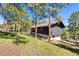 Exterior view of home surrounded by lush trees and green grass at 2976 Hiwan Dr, Evergreen, CO 80439
