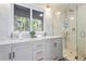 Bright bathroom featuring a dual sink vanity with stone countertop and glass-enclosed shower at 2976 Hiwan Dr, Evergreen, CO 80439