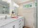 Bright bathroom featuring a dual sink vanity with stone countertop and glass-enclosed shower at 2976 Hiwan Dr, Evergreen, CO 80439