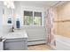 Bright bathroom featuring a single sink vanity with stone countertop, and bathtub with shower at 2976 Hiwan Dr, Evergreen, CO 80439