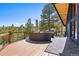 Relax on this deck with wooded views and comfortable seating under a blue sky at 2976 Hiwan Dr, Evergreen, CO 80439