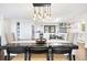 Bright dining room featuring a modern light fixture and view to kitchen and outdoor area at 2976 Hiwan Dr, Evergreen, CO 80439