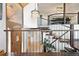 Inviting entryway featuring wooden staircase, stone accent wall, and stylish chandelier at 2976 Hiwan Dr, Evergreen, CO 80439