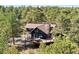 Stunning mountain home featuring an expansive deck surrounded by mature trees and beautiful landscaping at 2976 Hiwan Dr, Evergreen, CO 80439