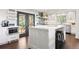 Well-lit kitchen island features black stools, stainless appliances, and an exterior door at 2976 Hiwan Dr, Evergreen, CO 80439