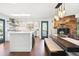 Open-concept kitchen and dining area boasts stainless appliances, center island, and stone fireplace at 2976 Hiwan Dr, Evergreen, CO 80439