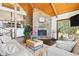 Inviting living room featuring a stone fireplace, wood ceilings, and a view of the dining area at 2976 Hiwan Dr, Evergreen, CO 80439