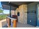 Stone outdoor kitchen area with built in grill and space for entertaining at 2976 Hiwan Dr, Evergreen, CO 80439