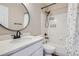 Bathroom features white vanity, round mirror and shower-tub combo with a floral curtain at 1169 N Tabor Dr, Castle Rock, CO 80104