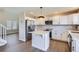 Stylish kitchen featuring white cabinets, stainless steel appliances, a center island, and sleek wood flooring at 1169 N Tabor Dr, Castle Rock, CO 80104