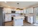 Bright, updated kitchen with white cabinets, stainless steel appliances, center island and light wood flooring at 1169 N Tabor Dr, Castle Rock, CO 80104