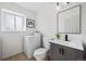 Cozy bathroom features modern vanity, updated fixtures, and combination washer/dryer at 9222 Albion St, Thornton, CO 80229