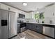 Modern kitchen with stainless steel appliances, gray lower cabinets, white upper cabinets and stylish backsplash at 9222 Albion St, Thornton, CO 80229