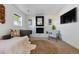 Bright living room with whitewashed fireplace, modern seating, and large screen television at 9222 Albion St, Thornton, CO 80229