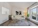 Bright and airy living room with modern flooring, white sofa, and ample natural light from the large window at 9222 Albion St, Thornton, CO 80229