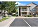 Two-story condo showcasing balconies, stone accents, manicured landscaping, and convenient parking spots at 4385 S Balsam St # 3-101, Littleton, CO 80123