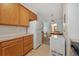 Bright kitchen featuring wood cabinets, white appliances, and tile flooring, leading into the dining area at 4385 S Balsam St # 3-101, Littleton, CO 80123