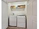 Efficient laundry room with a newer, full-sized washer and dryer, storage shelves, and neutral paint at 4385 S Balsam St # 3-101, Littleton, CO 80123