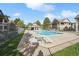 Community pool surrounded by lounge chairs, fencing, and nearby condo buildings with mature shade trees at 4385 S Balsam St # 3-101, Littleton, CO 80123