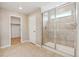 Bright bathroom with a glass-enclosed shower, beige tile, and a walk-in closet nearby at 39751 Congress Ln, Elizabeth, CO 80107