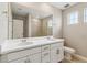 Modern bathroom featuring a double sink vanity, large mirror, and a shower with tiled walls at 39751 Congress Ln, Elizabeth, CO 80107