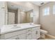 Bright bathroom featuring a double sink vanity with white countertops and modern fixtures, adjacent to a tiled shower at 39751 Congress Ln, Elizabeth, CO 80107