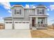 Charming two-story home featuring a three-car garage, stone accents, and a covered front porch at 39751 Congress Ln, Elizabeth, CO 80107