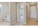 Bright hallway with hardwood floors leads to a bathroom with a white vanity and a separate room with carpet at 39751 Congress Ln, Elizabeth, CO 80107