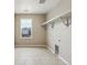 Functional laundry room with tile floor, built-in shelf, and ample natural light from a large window at 39751 Congress Ln, Elizabeth, CO 80107