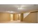 Open basement area with neutral carpeting and a staircase at 11186 E Baltic Dr, Aurora, CO 80014