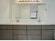 Bathroom features double sinks with gray cabinets, sleek hardware and a large mirror at 11186 E Baltic Dr, Aurora, CO 80014