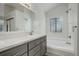 Bathroom features double sinks with gray cabinets, sleek hardware, tub, and lots of light at 11186 E Baltic Dr, Aurora, CO 80014