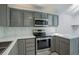 Updated kitchen features gray cabinets, stainless steel appliances, and attractive countertops and backsplash at 11186 E Baltic Dr, Aurora, CO 80014