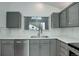 Well-appointed kitchen with modern appliances, stylish gray cabinets, and a bright, sunny window at 11186 E Baltic Dr, Aurora, CO 80014