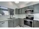 Updated kitchen featuring modern appliances, marble countertops, and stylish gray cabinetry at 11186 E Baltic Dr, Aurora, CO 80014
