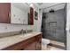 Modern bathroom features dark wood cabinets, granite countertop, and tiled shower with a shower head at 2020 Arapahoe St # 1250, Denver, CO 80205