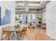 Open-concept living area boasts hardwood floors, exposed ceilings, and an adjoining balcony at 2020 Arapahoe St # 1250, Denver, CO 80205