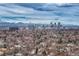 Aerial cityscape view featuring a neighborhood, buildings, trees, and cloudy skies at 1590 S Milwaukee St, Denver, CO 80210