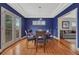 Elegant dining room with hardwood floors, blue walls, tray ceiling and glass doors leading to a patio at 1590 S Milwaukee St, Denver, CO 80210