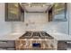 Close-up of a stainless steel gas cooktop with white subway tile backsplash and custom cabinets at 1590 S Milwaukee St, Denver, CO 80210