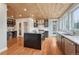 Kitchen with wooden ceiling, center island, stainless steel appliances, built-in desk and hardwood floors at 1590 S Milwaukee St, Denver, CO 80210