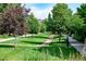 Lush green community area with mature trees, walking path and attractive landscaping at 817 Uinta Way, Denver, CO 80230