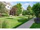 Beautiful, well-manicured lawn and landscaping of a neighborhood with sidewalks and mature trees at 817 Uinta Way, Denver, CO 80230