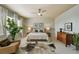 A bright main bedroom is furnished with a modern ceiling fan, matching nightstands, and large decorative houseplant at 817 Uinta Way, Denver, CO 80230