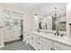 Bright bathroom featuring double vanity sinks, a walk-in shower and a well-organized walk-in closet at 1100 N Grant St # 208, Denver, CO 80203