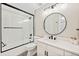 Well-lit bathroom with a framed shower, a round mirror and a modern single vanity at 1100 N Grant St # 208, Denver, CO 80203